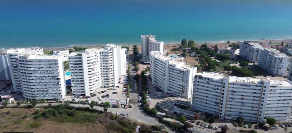 Strand und eine Reihe hoher Wohnhäuser am Meer von oben, Küste von Mersin