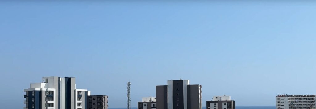 Высотные жилые дома и море на горизонте в Томюке, Мерсин